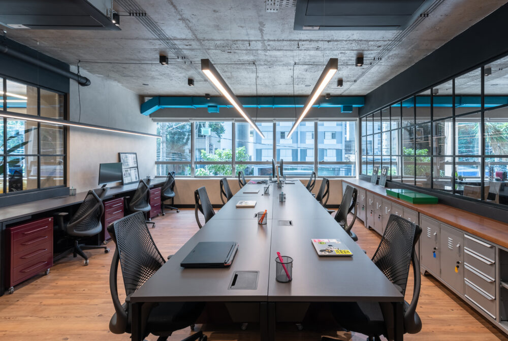 Ambiente criativo com mural e janelas amplas em projeto da Labra