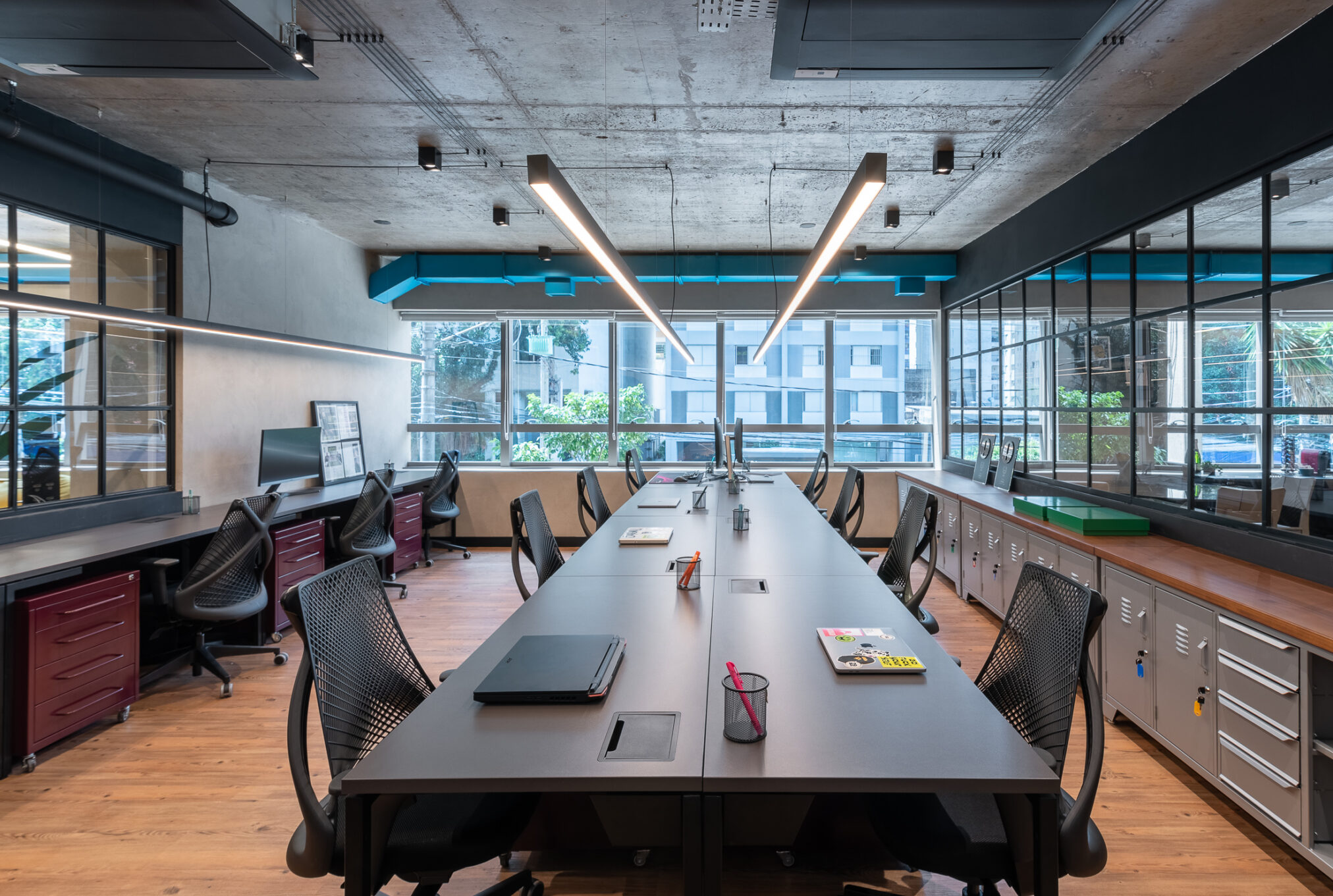 Ambiente criativo com mural e janelas amplas em projeto da Labra