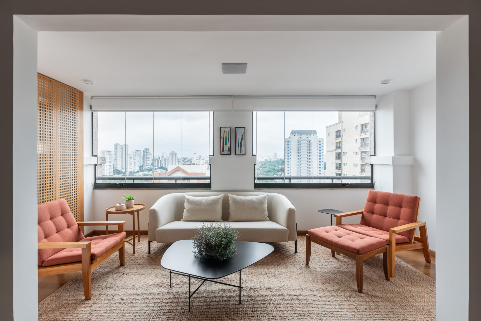 Sala de estar clara com poltronas e janelão em projeto da Labra