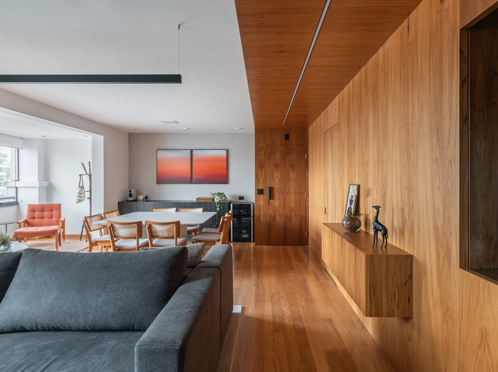 Living com sofá e marcenaria em madeira em projeto residencial da Labra