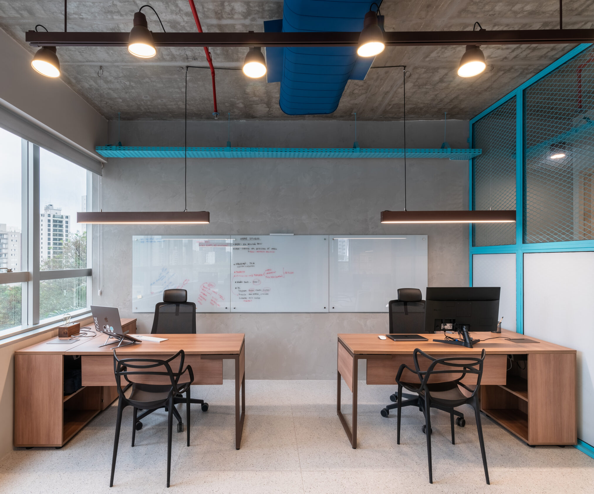 Escritório com mesas e estrutura azul em projeto corporativo da Labra