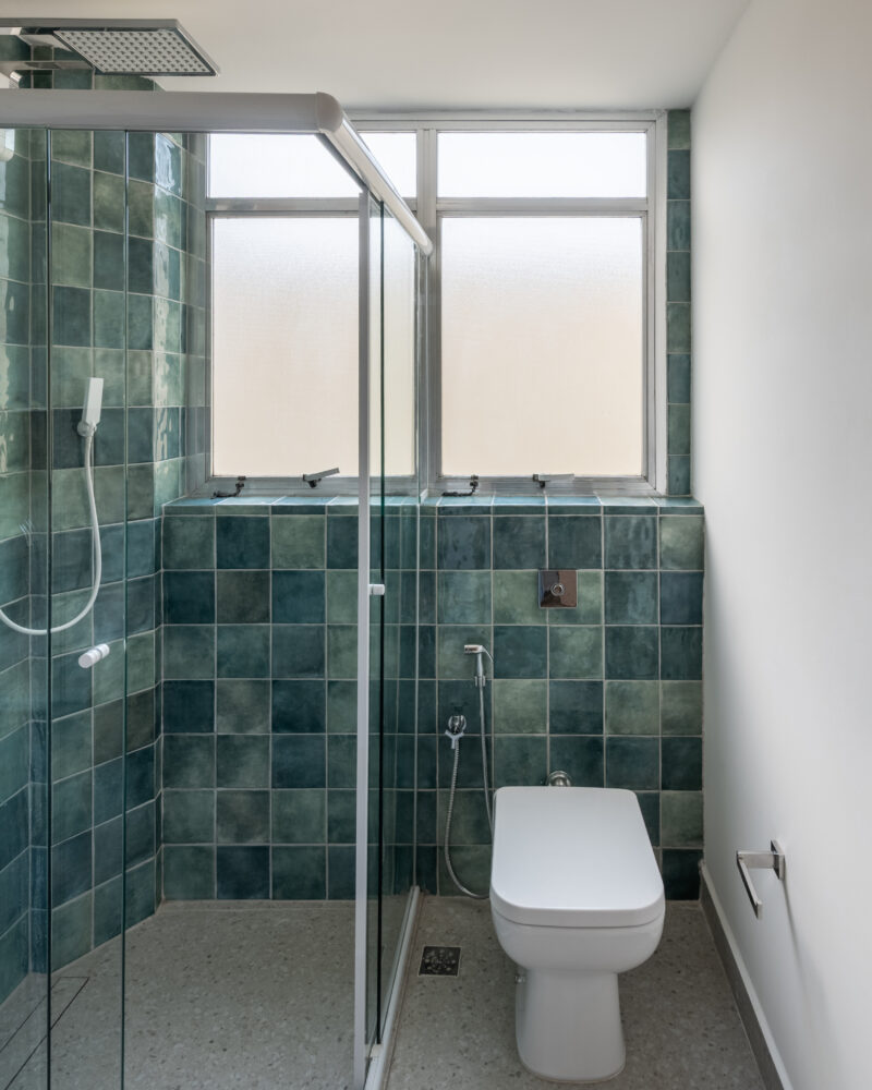 Banheiro com revestimento verde e espelho em projeto residencial da Labra