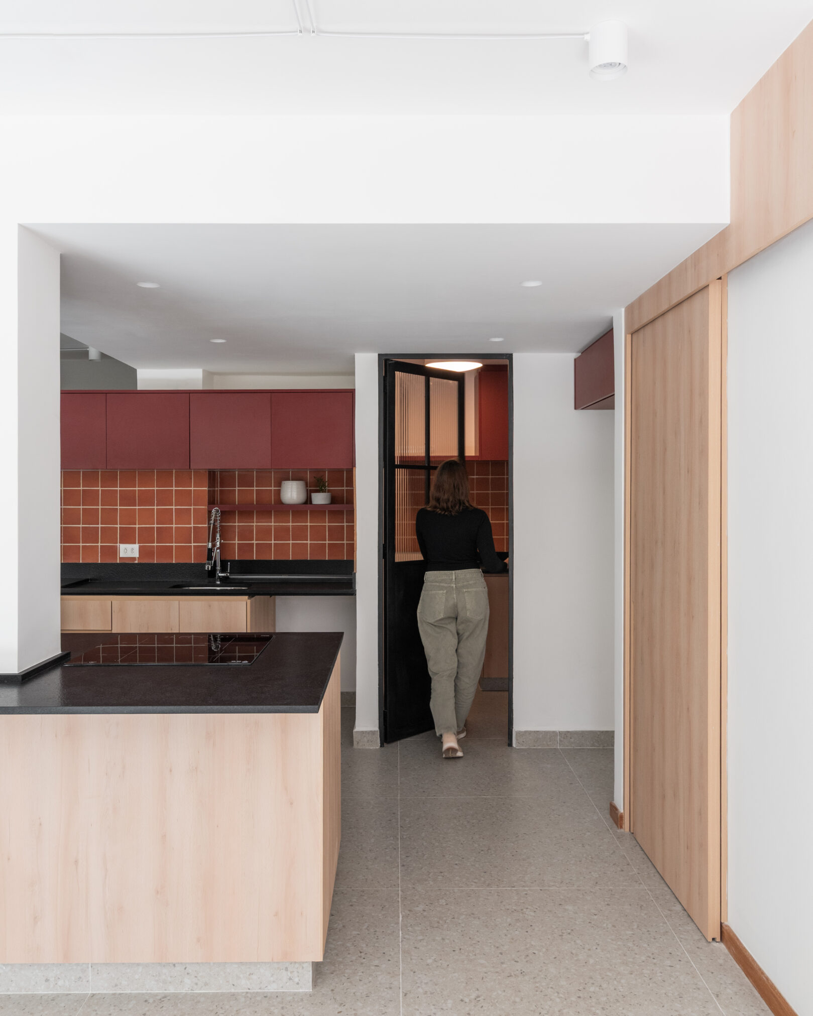 Cozinha integrada com bancada e revestimento terracota em projeto da Labra